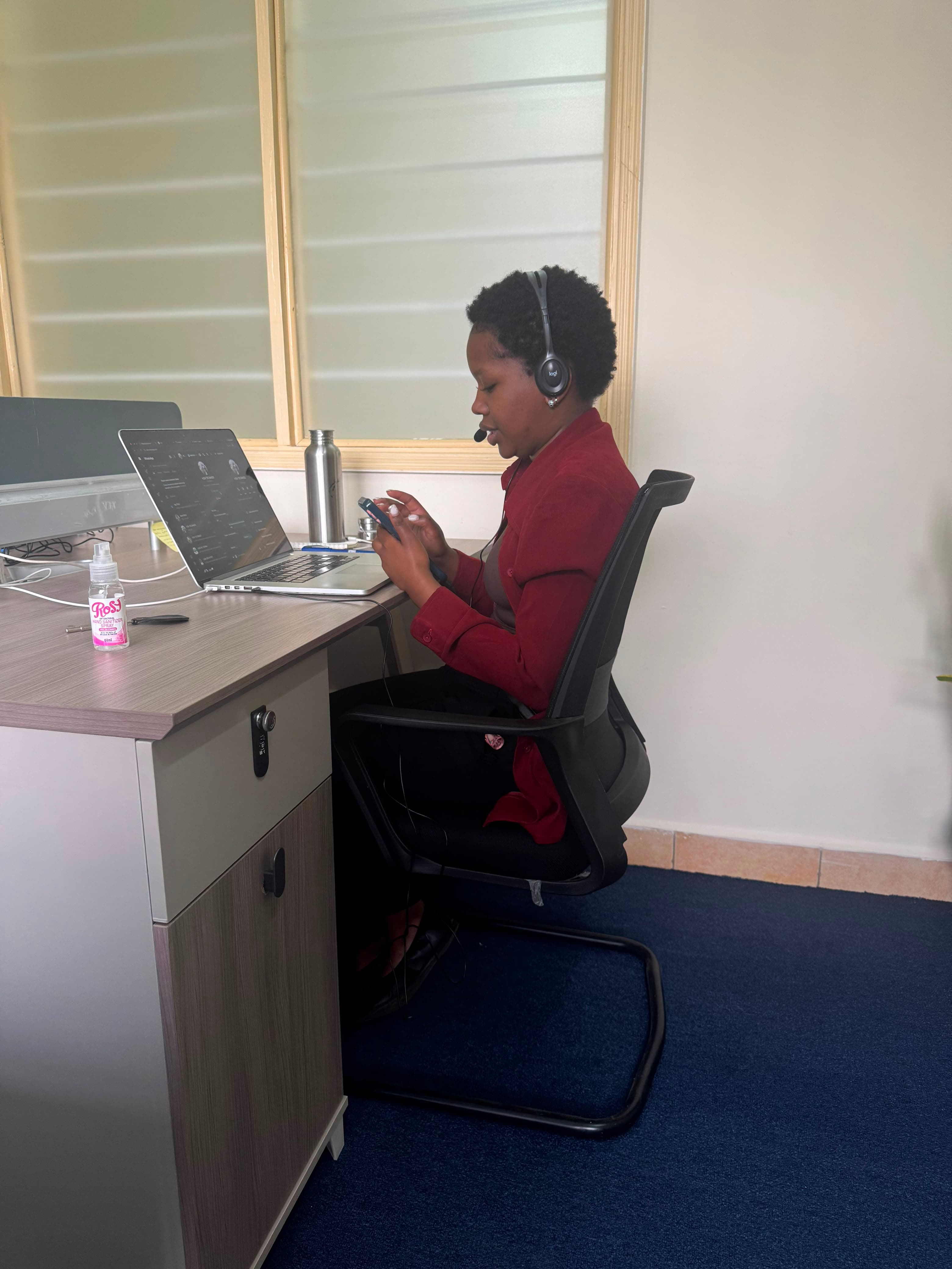 Sikika team member handling a customer call on a headset at a support desk